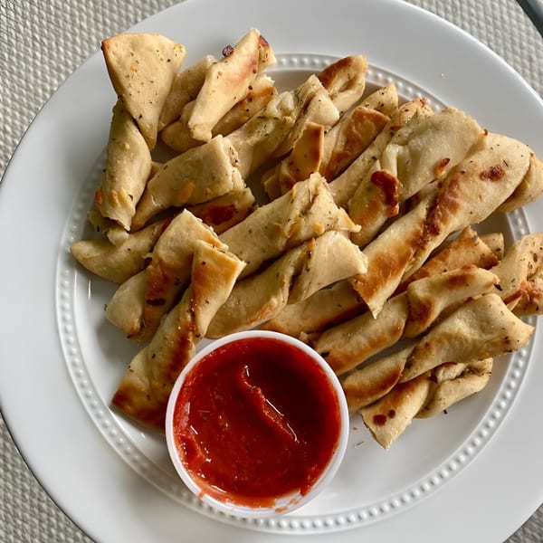 Mama Mimi's Take 'N Bake Pizza's twisted breadsticks with herbs and a side of marinara sauce.